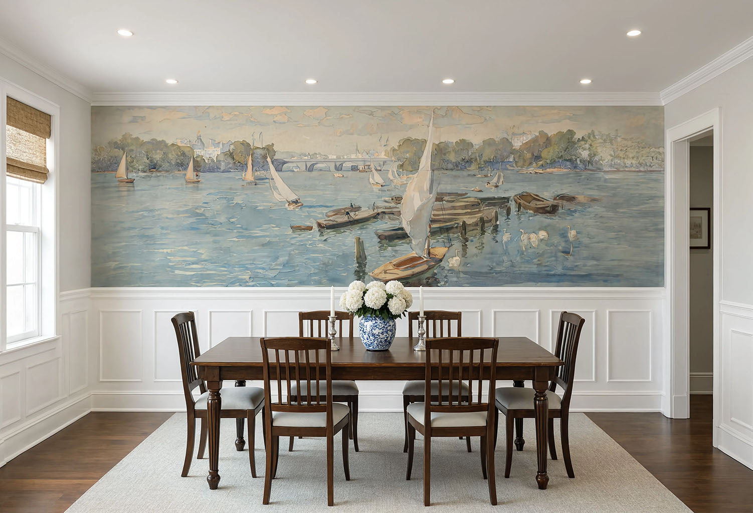 Coastal sailboat wall mural installed above white wainscoting in a dining room