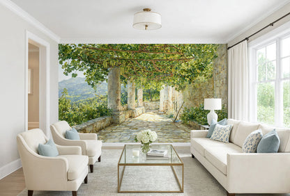 A 19th-century oil painting wall mural by Janus la Cour showing a stone loggia pathway in Capri beneath a lush green grapevine pergola with hanging grapes.