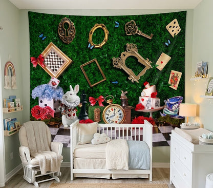 A styled nursery room featuring a large green wall tapestry with an Alice in Wonderland theme, including playing cards, keys, frames, a rabbit, and a clock. The room is furnished with a white crib, a white rocking chair, and a white dresser.