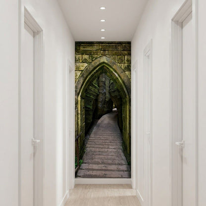 A hallway with white walls and doors, featuring a large wall mural or wallpaper insert depicting a stone gothic archway and wooden staircase.