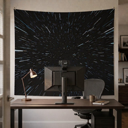 Hyperdrive space tapestry with light speed star streaks hung on a gaming room wall behind a desk setup