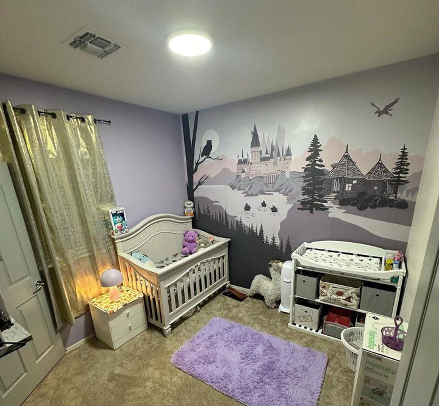 Pink Nursery room with crib and decorative wall mural.