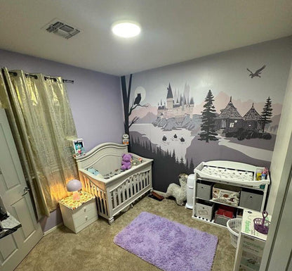 Pink Nursery room with crib and decorative wall mural.