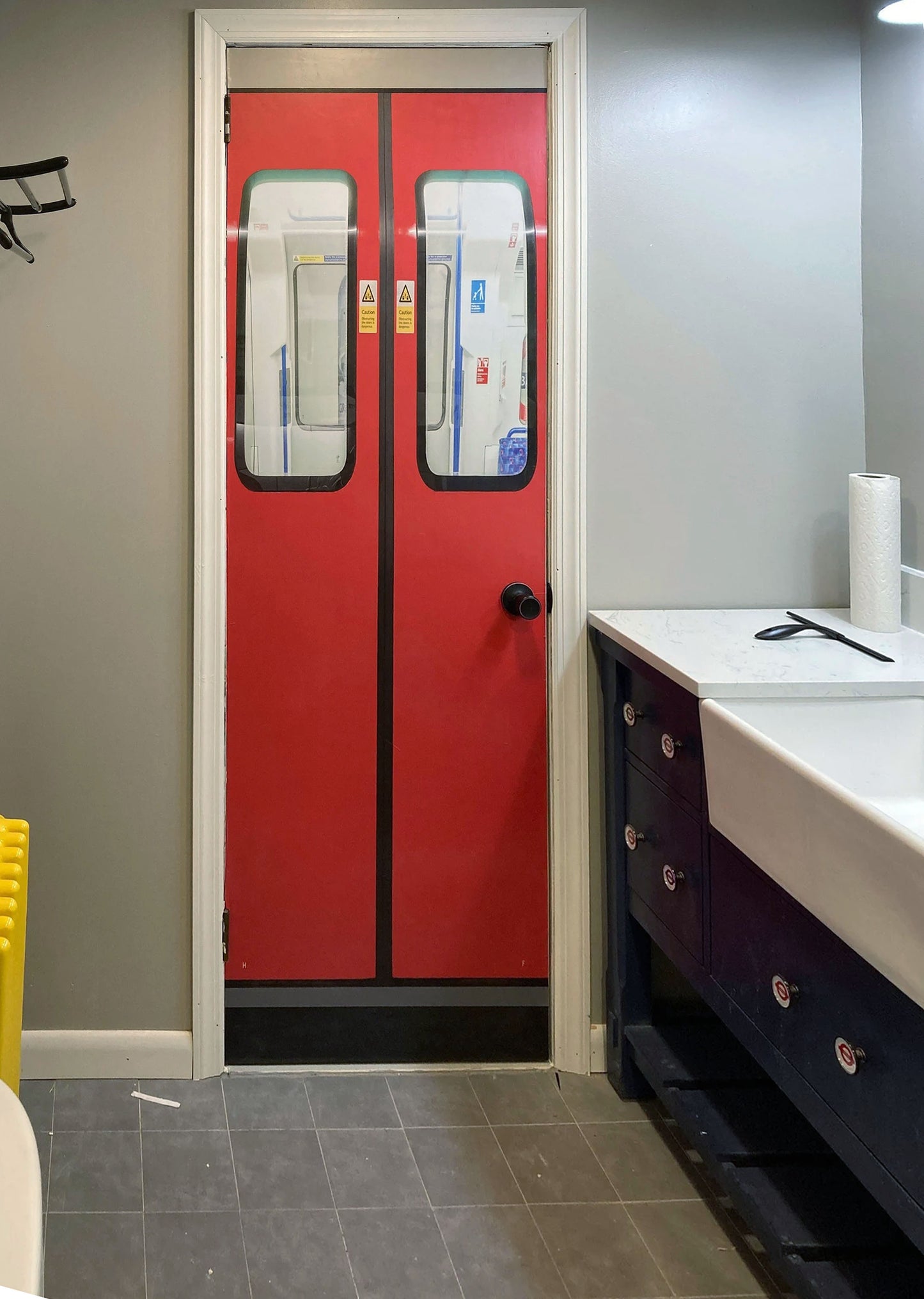 Red door with glass panels in a bathroom setting