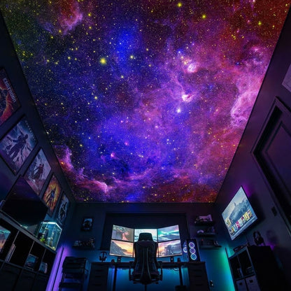 A dark home office or gaming room with a large ceiling panel printed with a vivid galaxy nebula scene in purple, blue, pink, and orange, with a desk setup, chair, shelves, and framed wall art visible below.