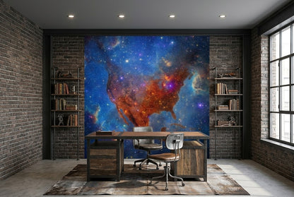A large wall mural of the United States map filled with a colorful nebula galaxy design, displayed in a modern office room with brick walls, a desk, and chairs.
